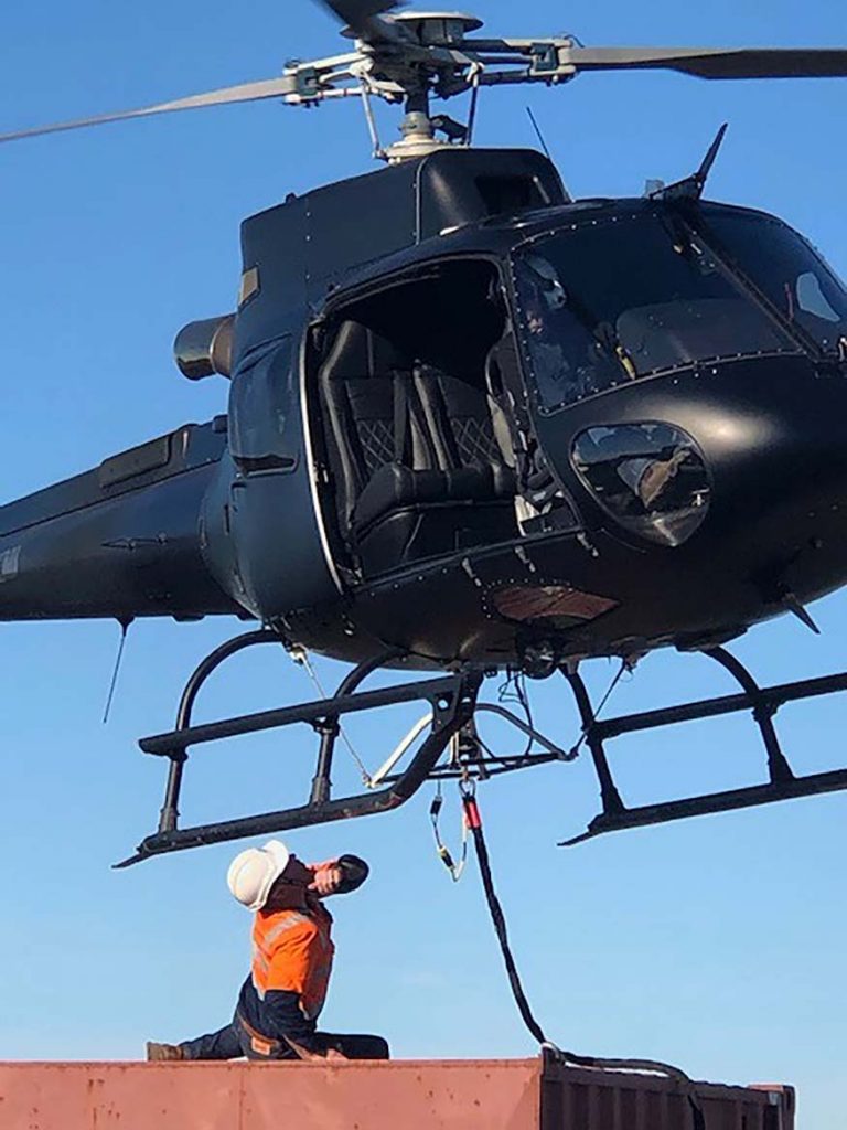 Helicopter hovering over engineer at Jan Juc Beach access steps installation